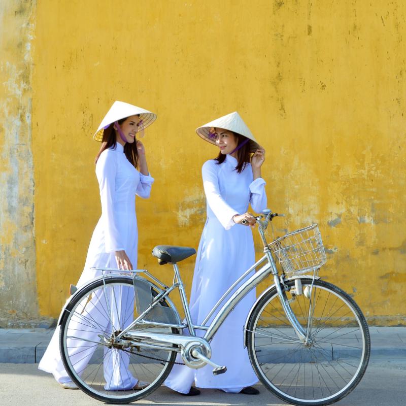 zwei vietnamesische Frauen mit Fahrrad